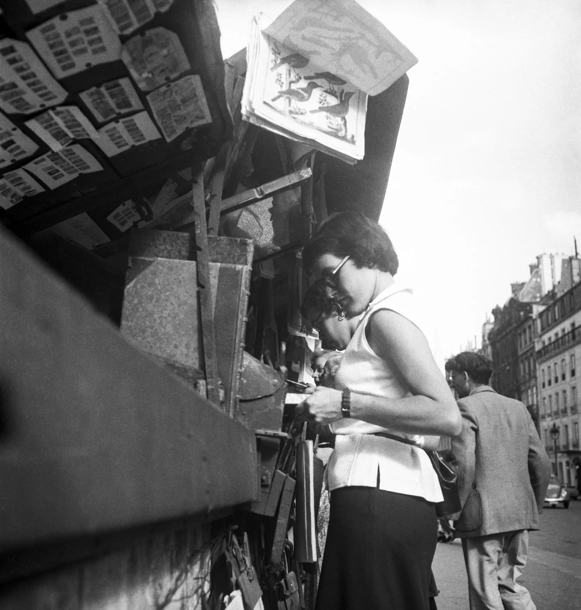 A woman examines a potential purchase from the <em>bouquinistes</em> during springtime, March 21, 1951 © Keystone-France/Gamma-Keystone/ Getty Images