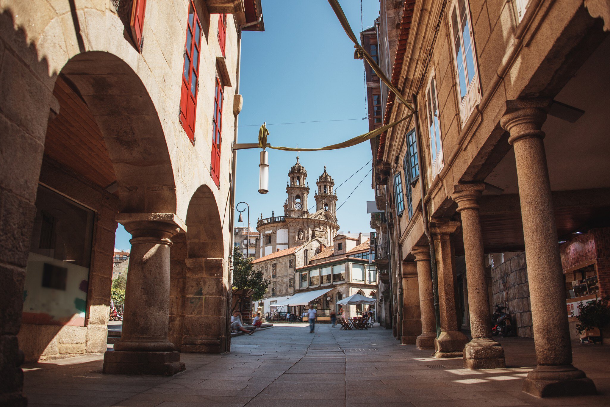 View down a street in the old town of Pontevedra, Spain, with the towers of the Santuario da Virxe Peregrina in the background.
