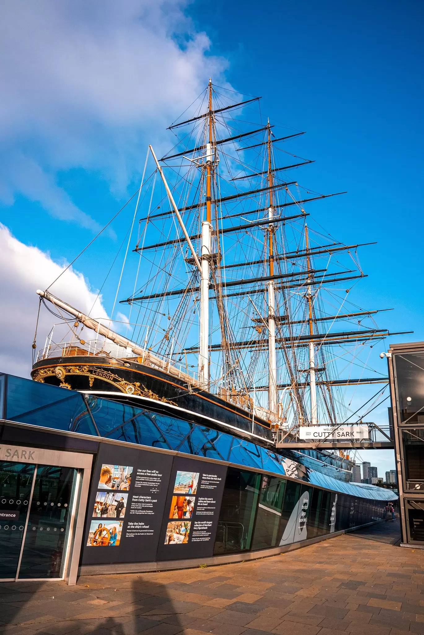View of the Cutty Sark and information billboard in Greenwich, London, UK.
