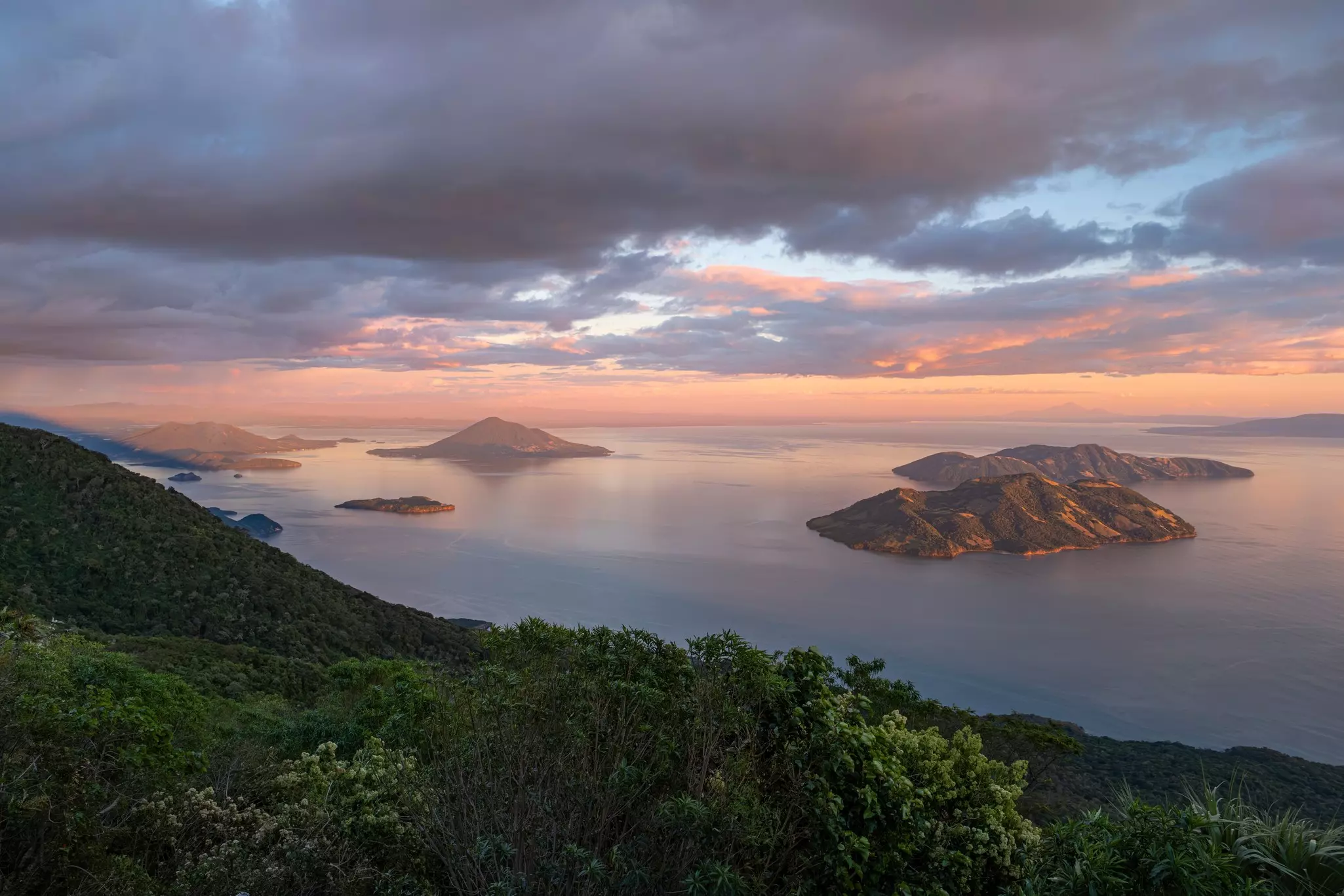 A pastel-colored sunset over several islands
