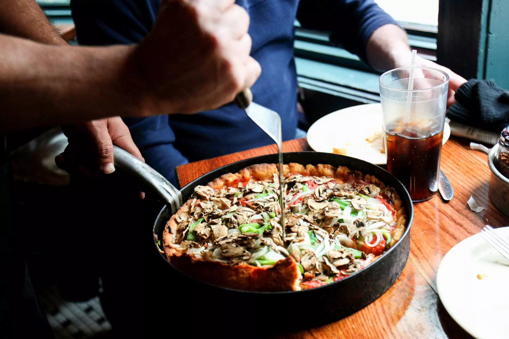 Serving up a deep dish pizza at Pizzeria Uno in Chicago. © Nancy Stone/Chicago Tribune/Tribune News Service via Getty Images