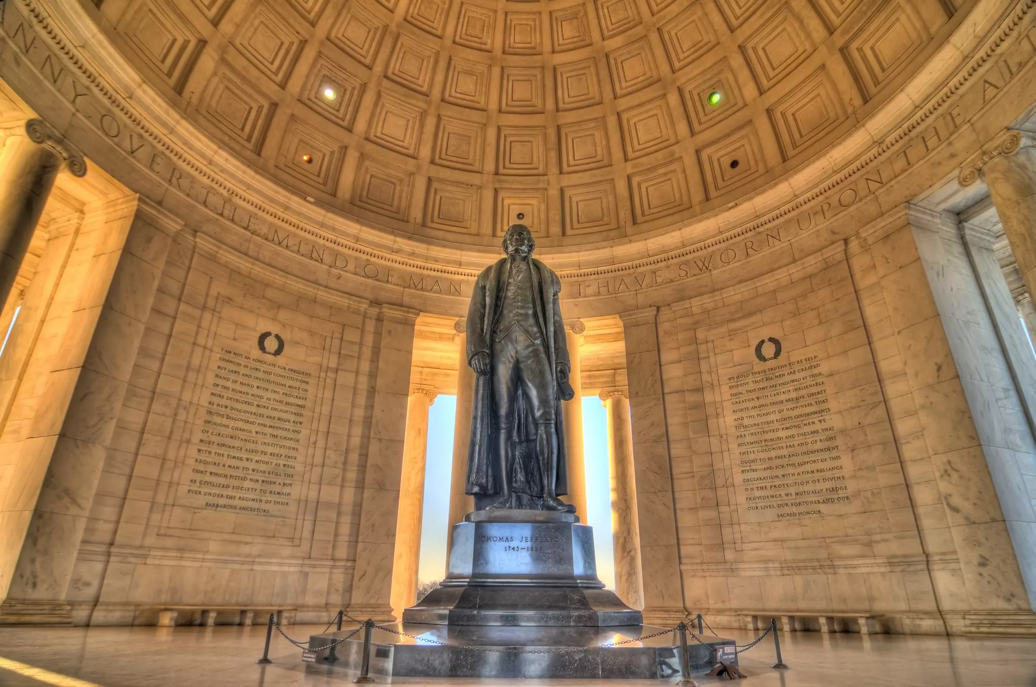 A view of the interior of the Jefferson Memorial, with a bronze statue of Thomas Jefferson stood on a plinth.
