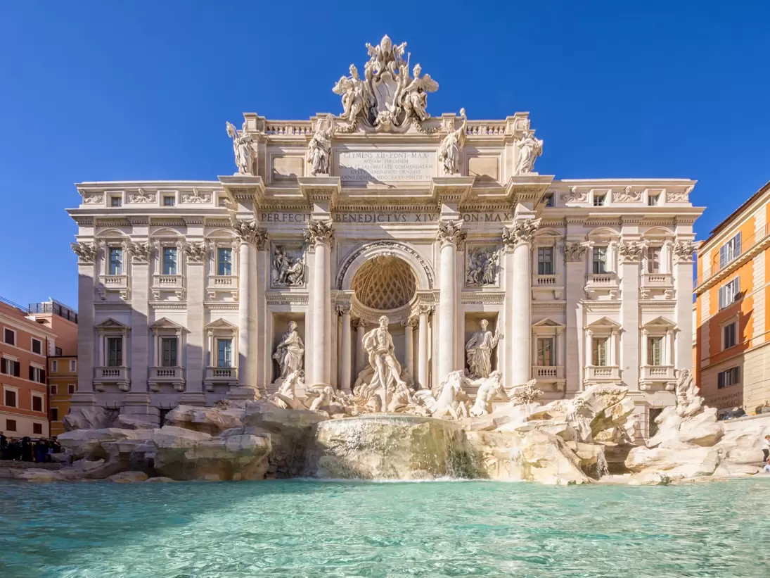 The blue waters of Trevi Fountain are backed by the grandiose Baroque sculptures and mansion-like facade