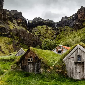 Icelandic turf houses and rocks with waterfall in the background near Kalfafell vilage, Southern Iceland, License Type: media, Download Time: 2025-12-10T17:43:38.000Z, User: sevelynd12, Editorial: false, purchase_order: 56500 - T&R or Kids, job: Global Publishing WIP, client: Dream Trips of Europe, other: Sharon Dortenzio