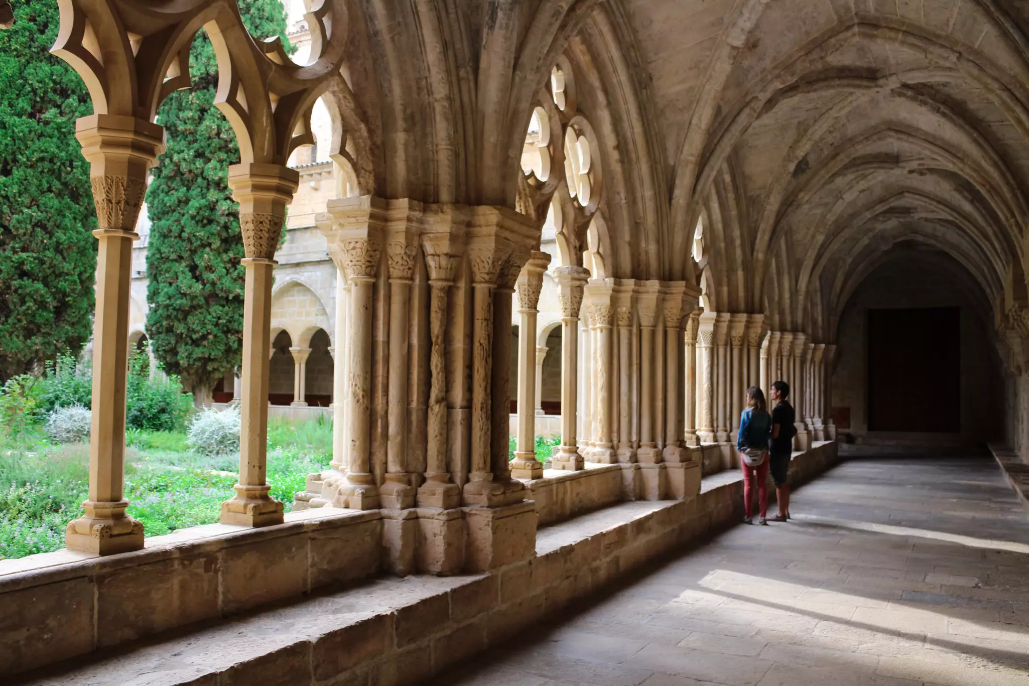 Two visitors in the cloister of a monastery in Spain.