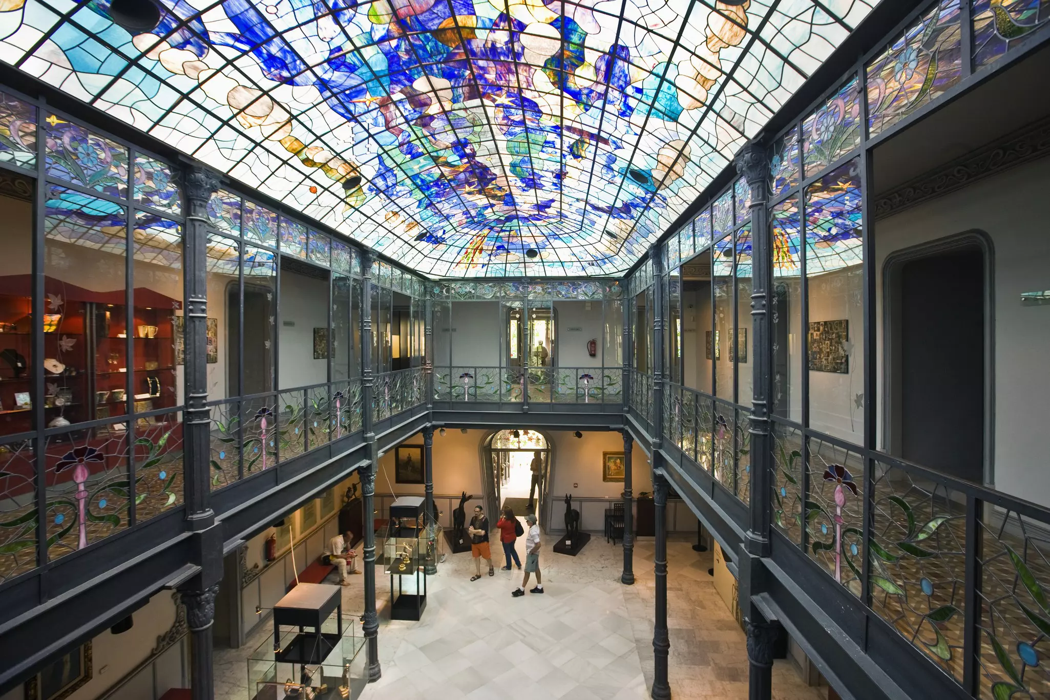 Interior of the Museo de Art Nouveau y Art Deco in Casa Lis with a colourful stained glass ceiling