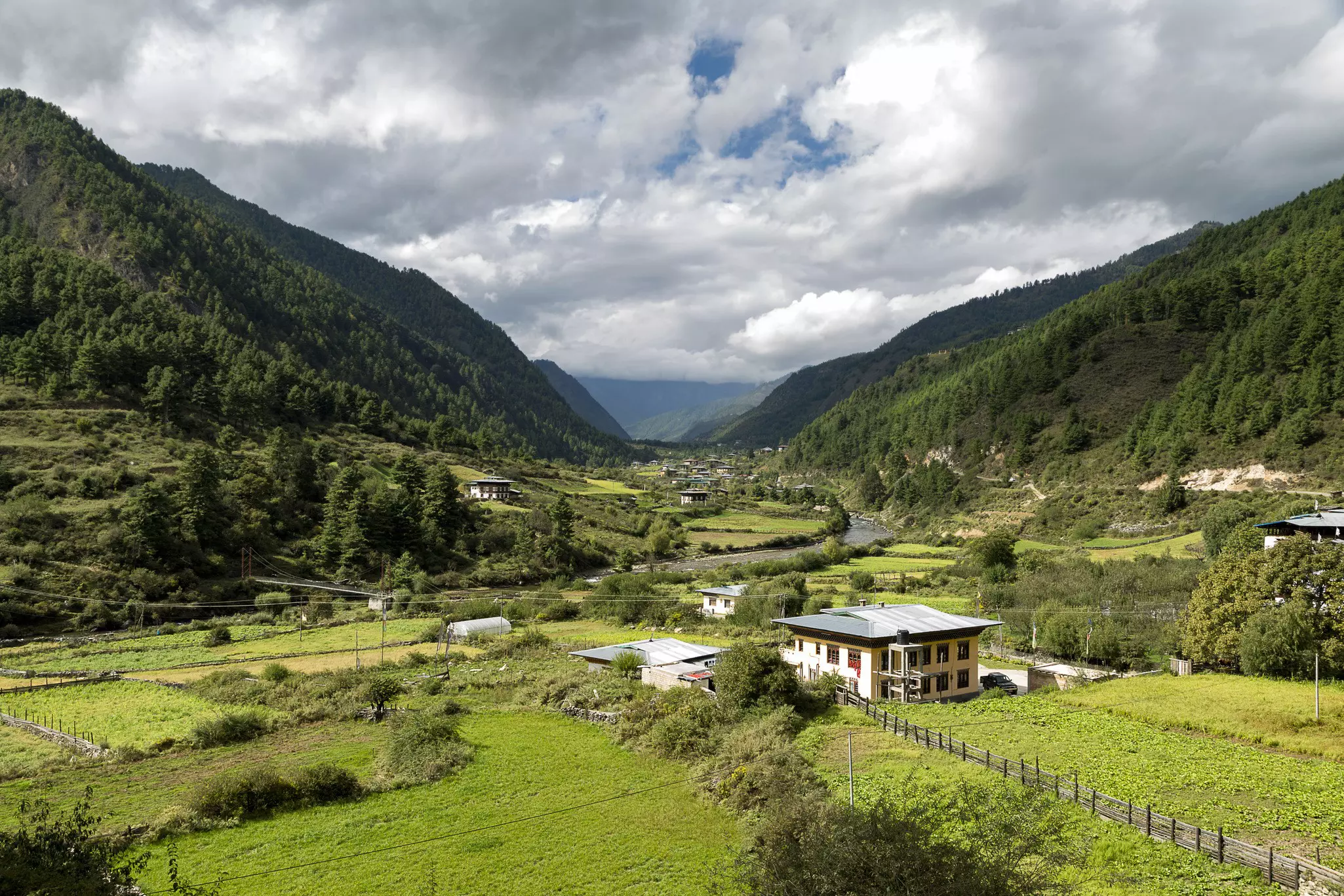A valley surrounded by lush green mountains.