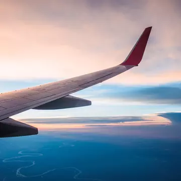 Wing of plane flying over land