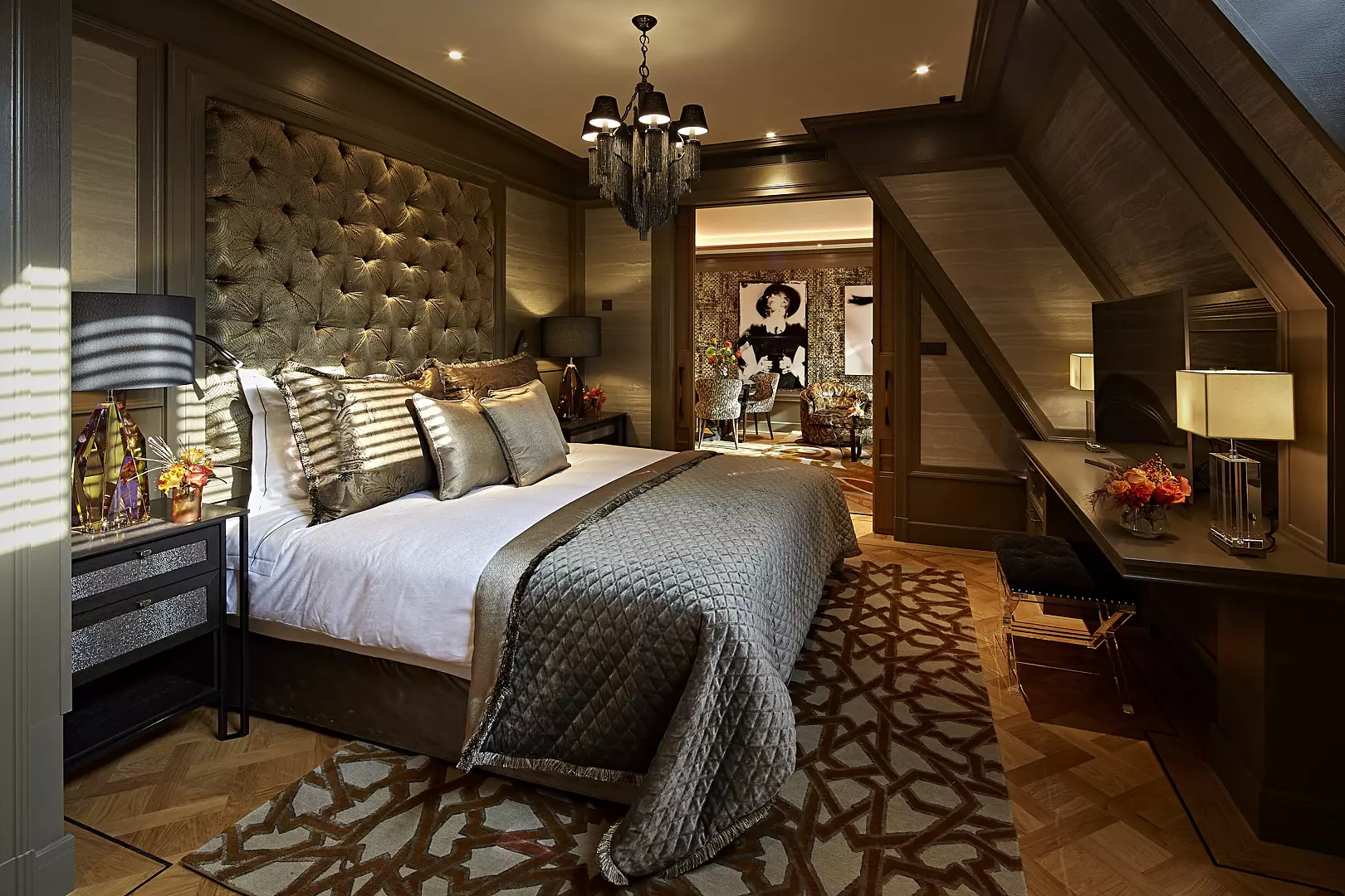 A plush bedroom in a luxury boutique hotel, with velvet decor and a spacious lounge area off the bedroom.