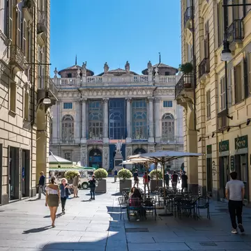People walking around Via Garibaldi of Madama Palace (Palazzo) in Piazza Castello on a sunny day.