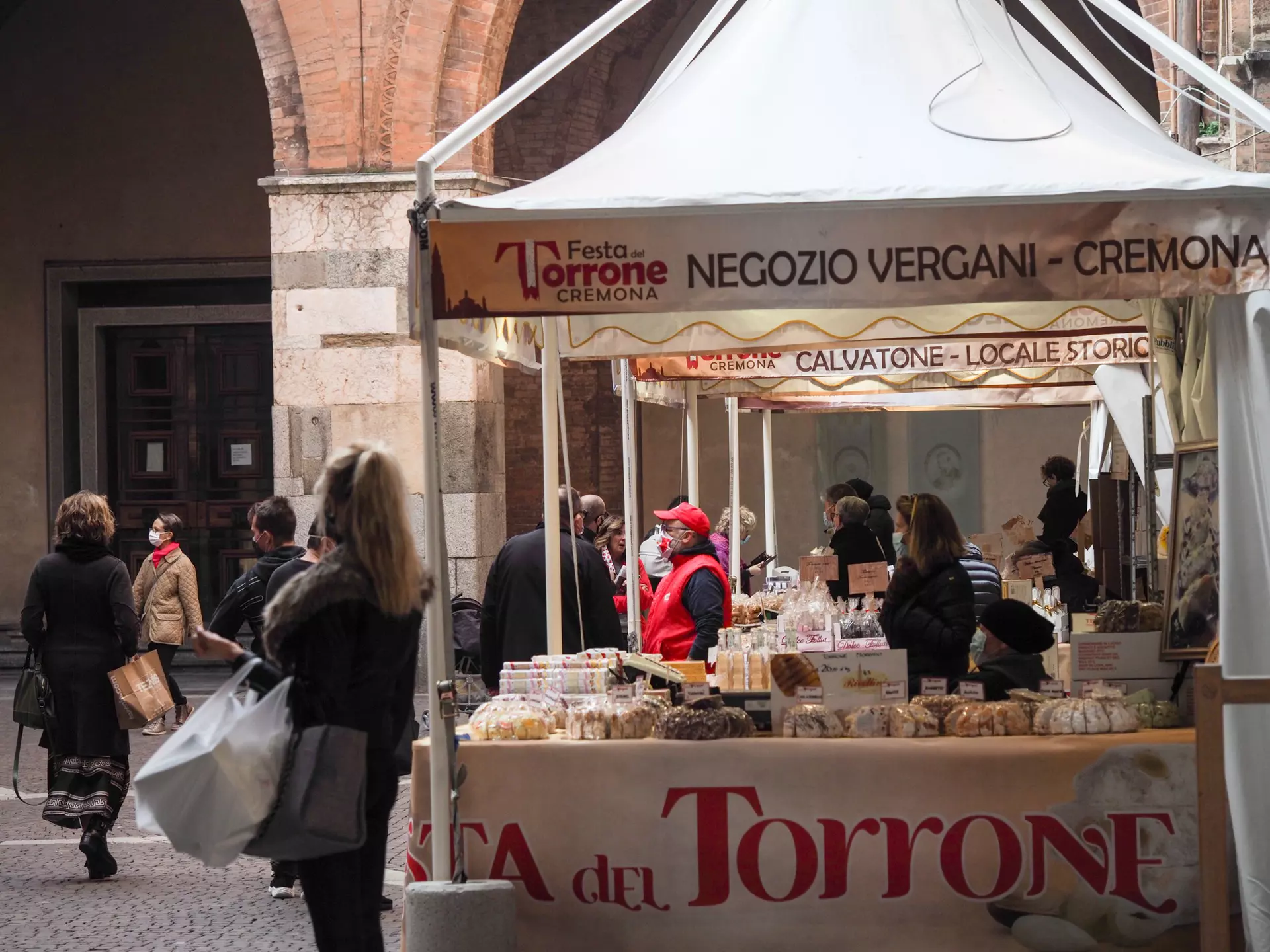 Cremona, Lombardy, Italy - October 18th 2020 - Nougat Torrone festival in covid-19 times , people wearing face mask and preview chistmas spirit, License Type: media, Download Time: 2024-12-16T18:59:12.000Z, User: comptonsheldon109, Editorial: true, purchase_order: 56530 - Guidebooks, job: Global Publishing WIP, client: Italian Lakes 4, other: Compton Sheldon