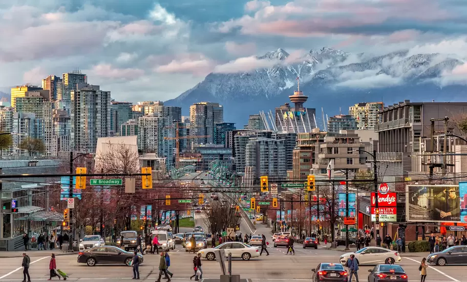 View of downtown Vancouver, Canada, during the day with snow-capped mountains in the background.