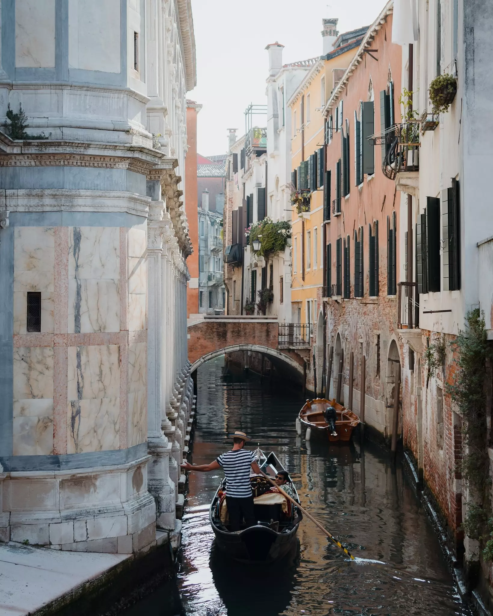 Gondolieri navigating through the canals of Venezia.