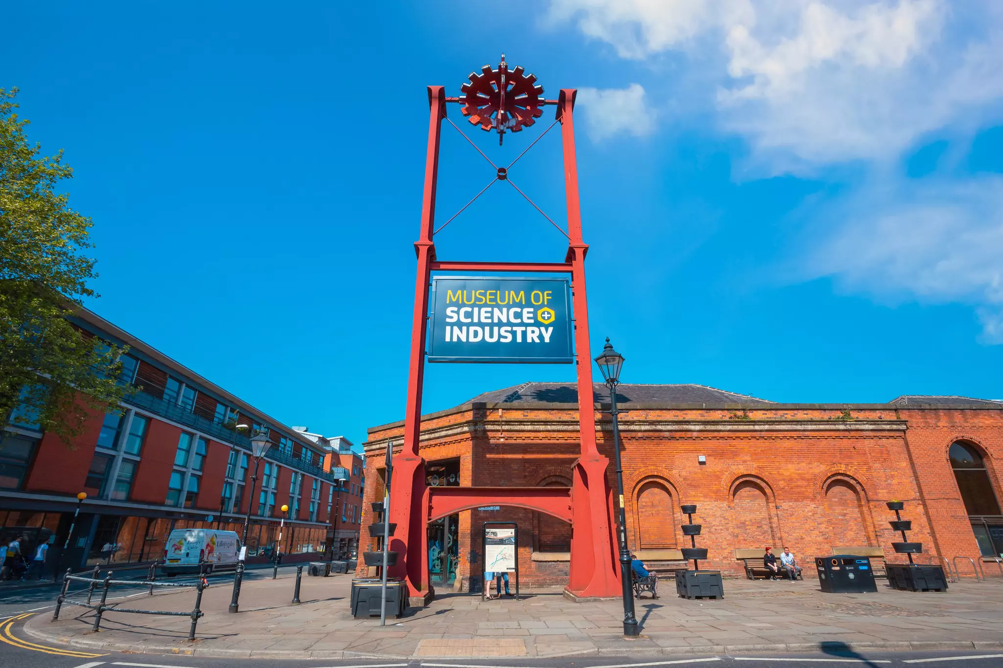 A large industrial-style sign saying "Museum of Science + Industry" marking the entrance to a red-brick building
