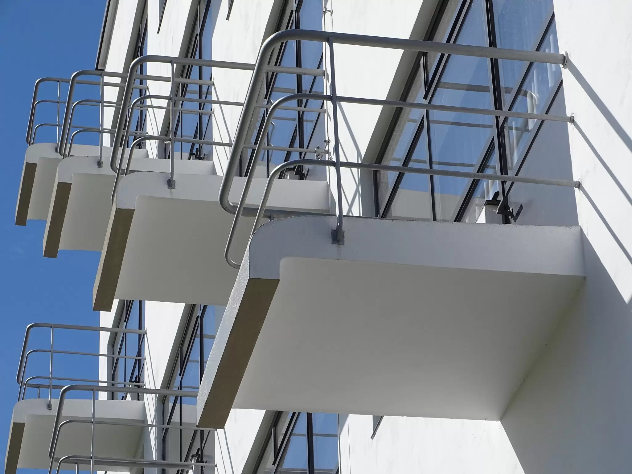 Small, white balcony spaces with chrome metal railings