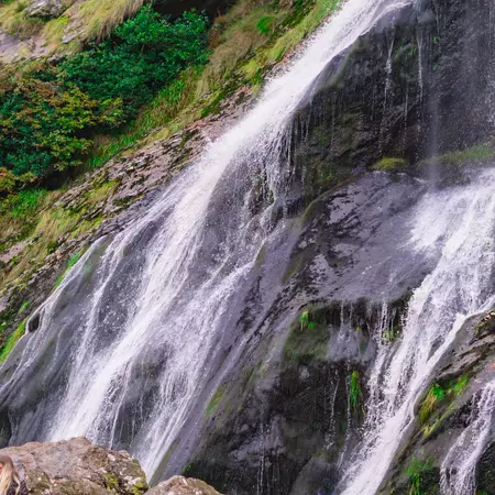Man standing in front of the Powerscourt Waterfall near Enniskerry.
