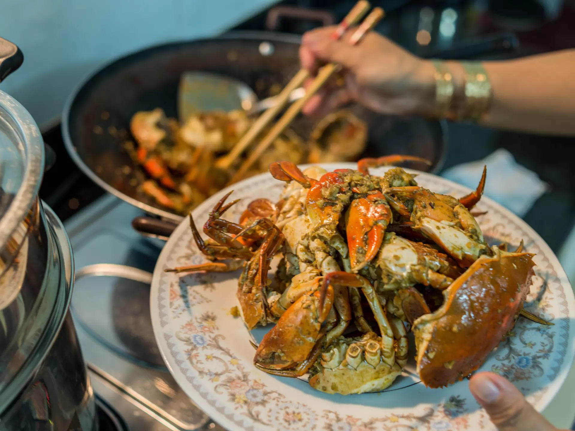 A lady prepares home-cooked chili crab for a family dinner.