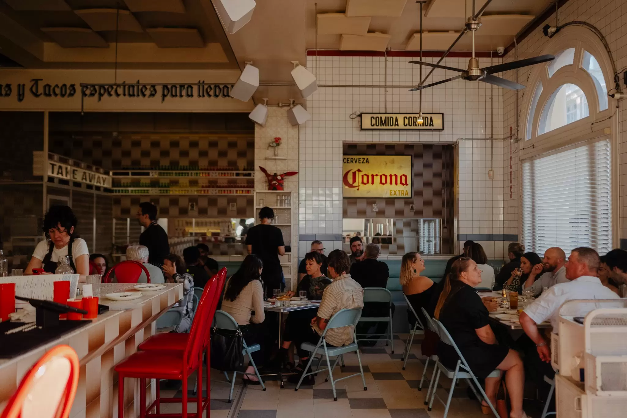 Diners at a Mexican cantina and bar in Collingwood, Melbourne with retro signs on the wall 