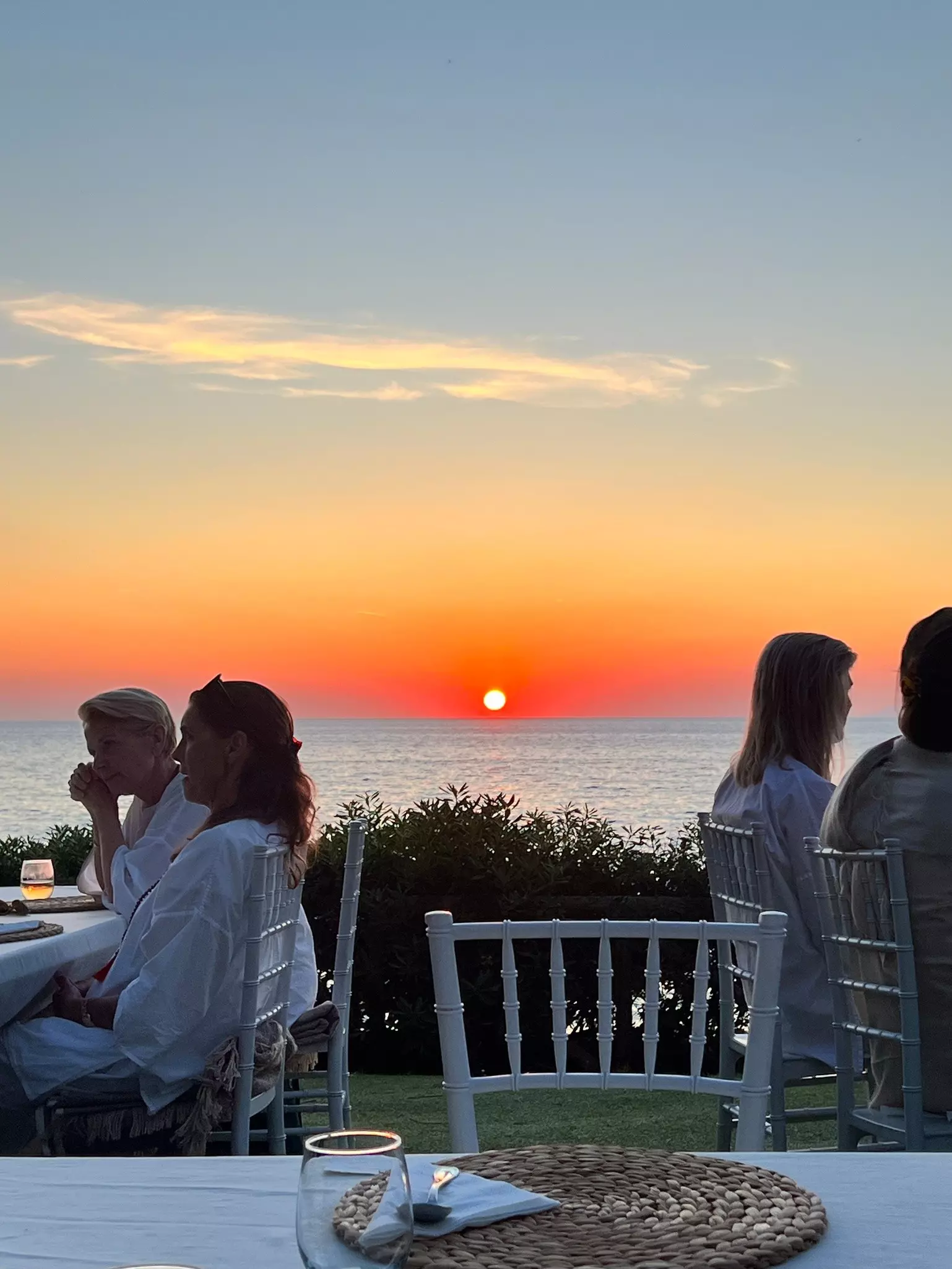 View from Palazzo Belmonte in Italy at sunset with people sitting in semi-silhouette talking together