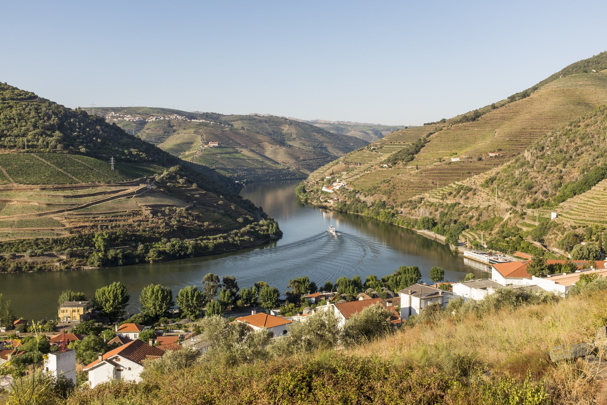View over the River Douro and the Douro Valley, with the riverfront town of Pinhão, Portugal, in the foreground.