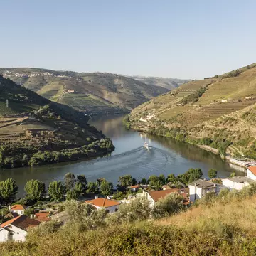 View over the River Douro and the Douro Valley, with the riverfront town of Pinhão, Portugal, in the foreground.