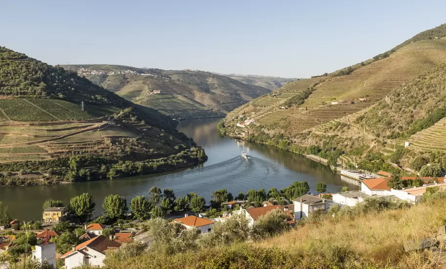 View over the River Douro and the Douro Valley, with the riverfront town of Pinhão, Portugal, in the foreground.