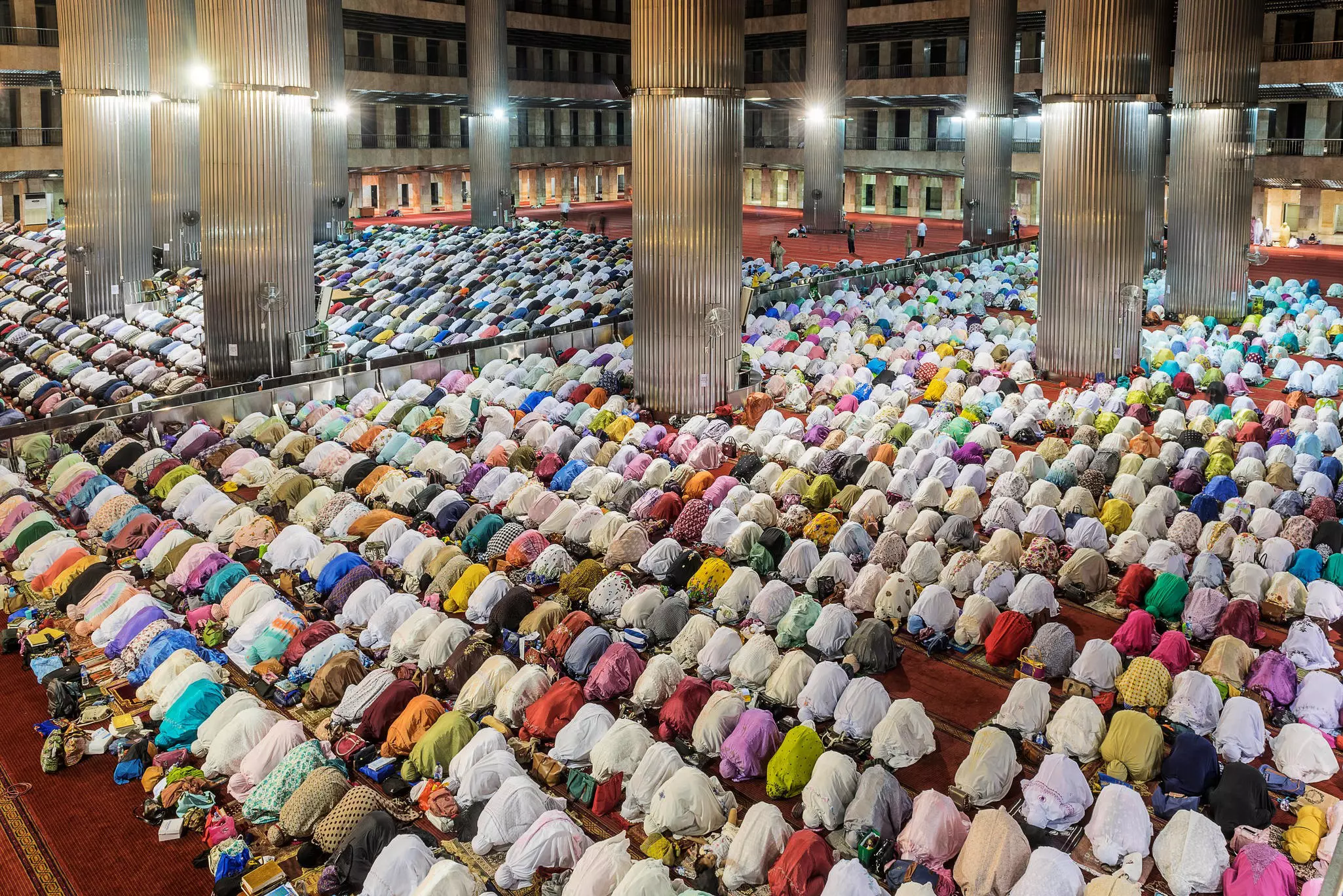 Men and women praying inside the Istiqlal Mosque in Jakarta, Java, Indonesia.