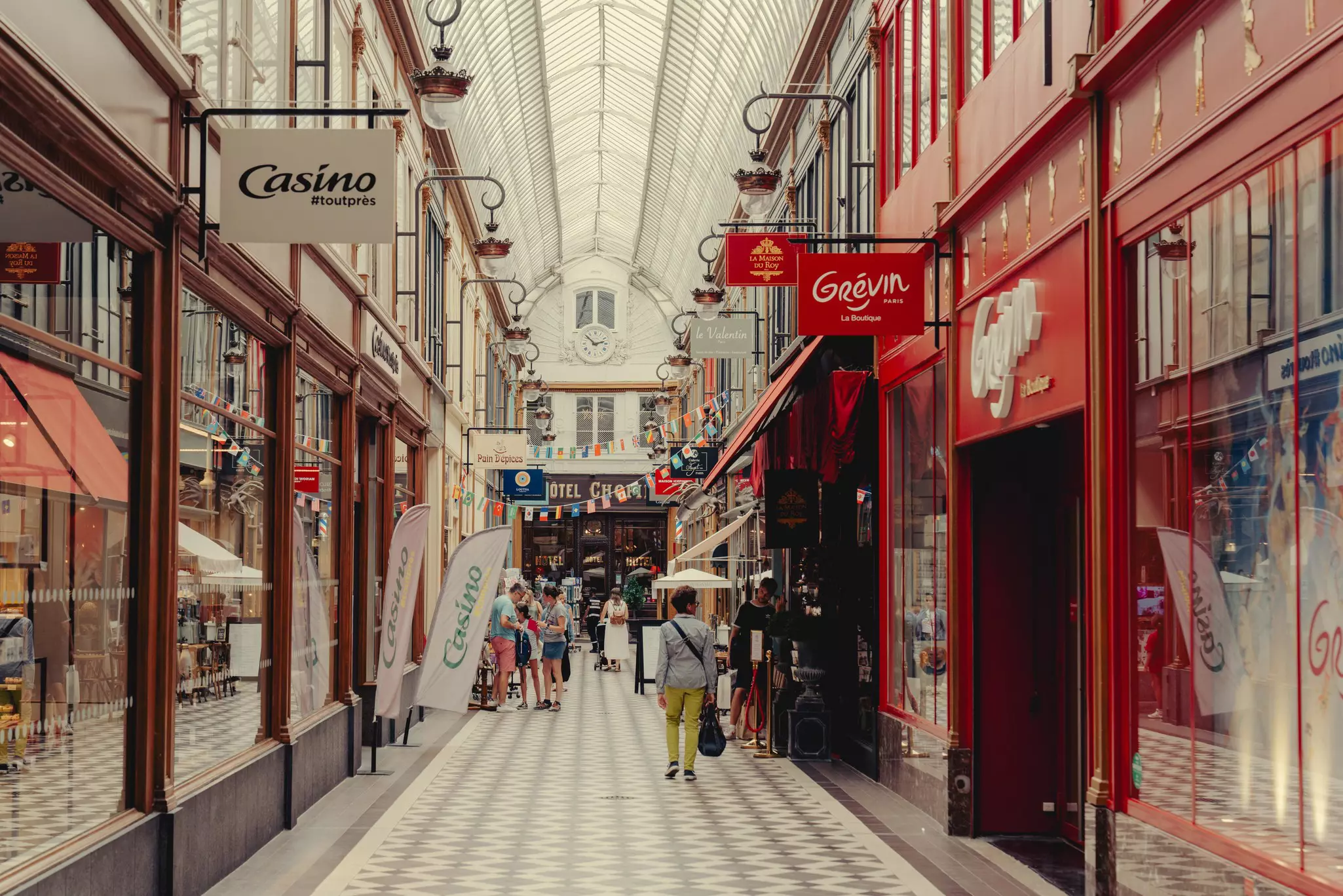 A covered passage with a tiled walkway and shops on either side.