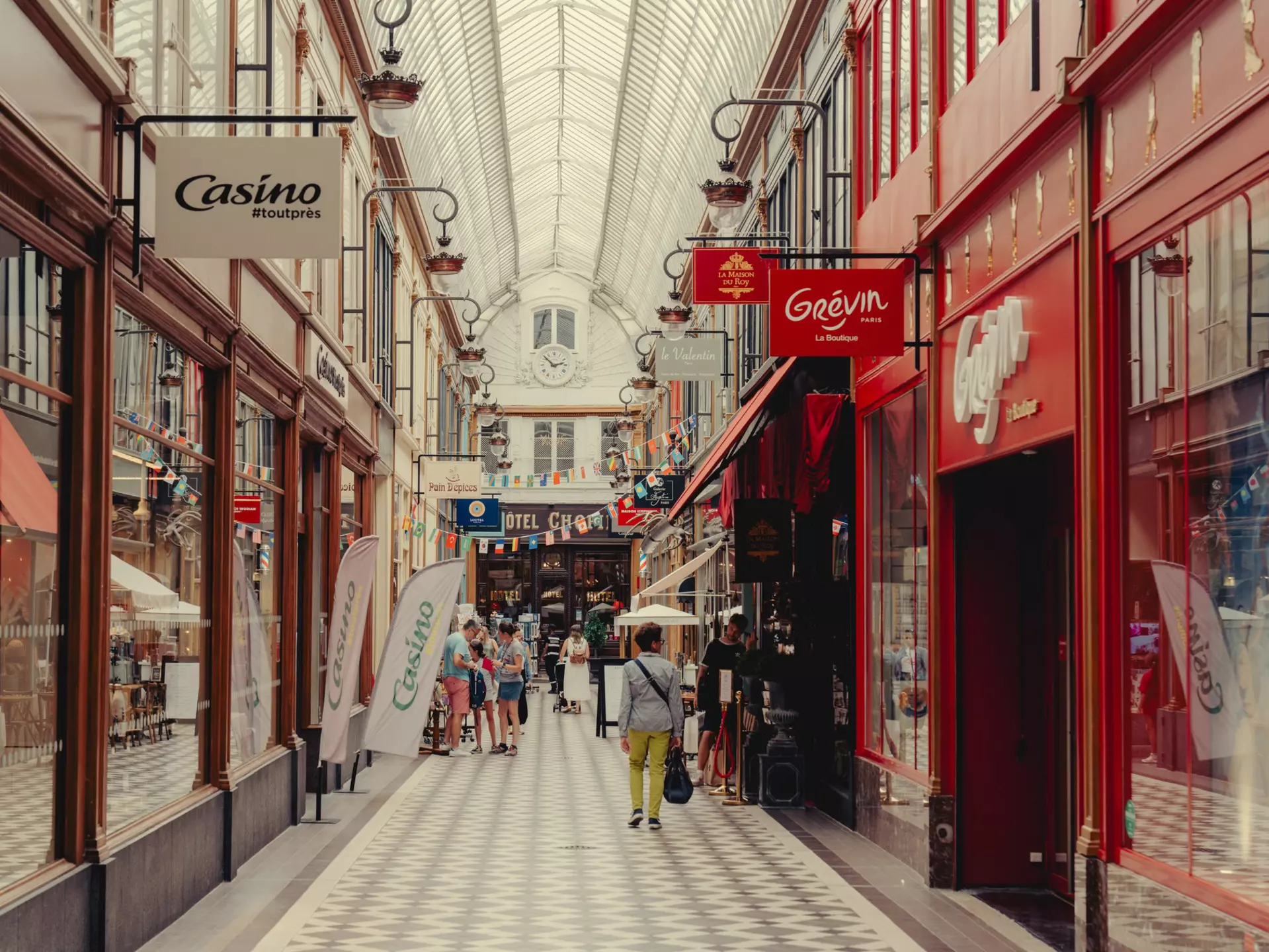 A covered passage with a tiled walkway and shops on either side.