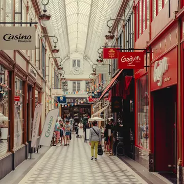 A covered passage with a tiled walkway and shops on either side.