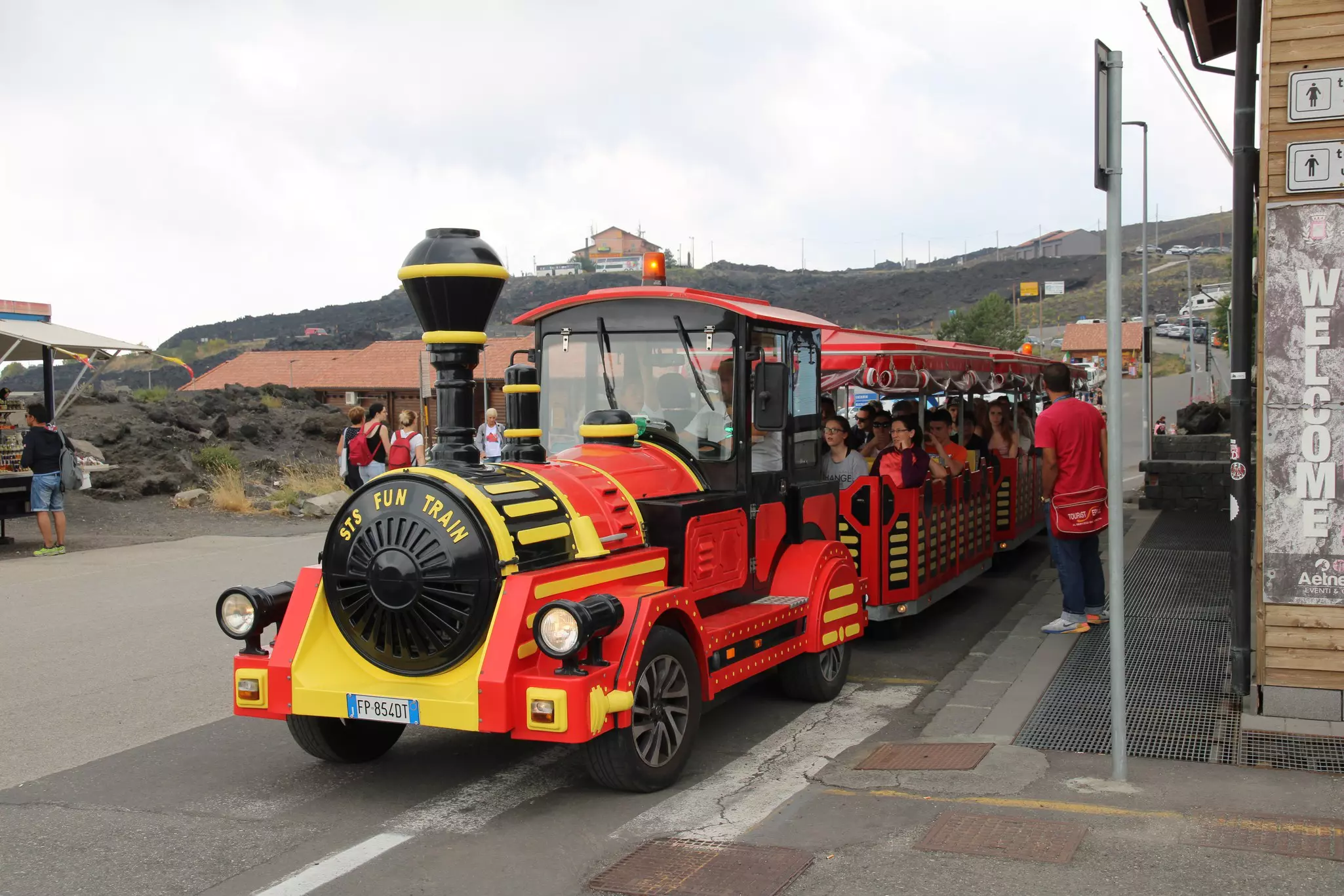A red and white train collects families and children.