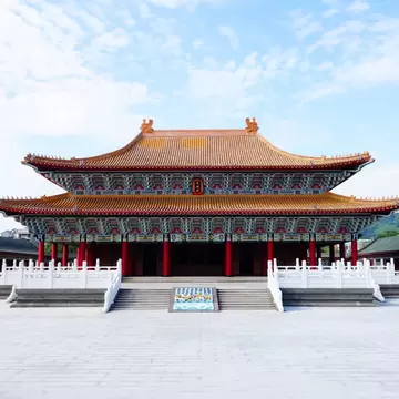A temple with a tiered orange roof and red columns in Kaohsiung.