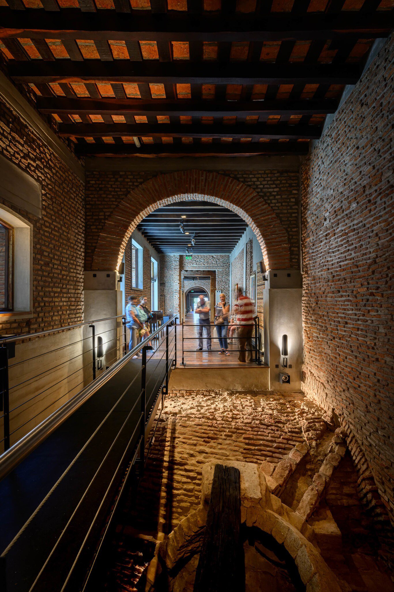 Interior of El Zanjón de Granados in Buenos Aires, Argentina.  Brick walls and arches, with tourists looking at the installation.