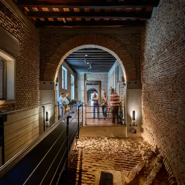 Interior of El Zanjón de Granados in Buenos Aires, Argentina.  Brick walls and arches, with tourists looking at the installation.