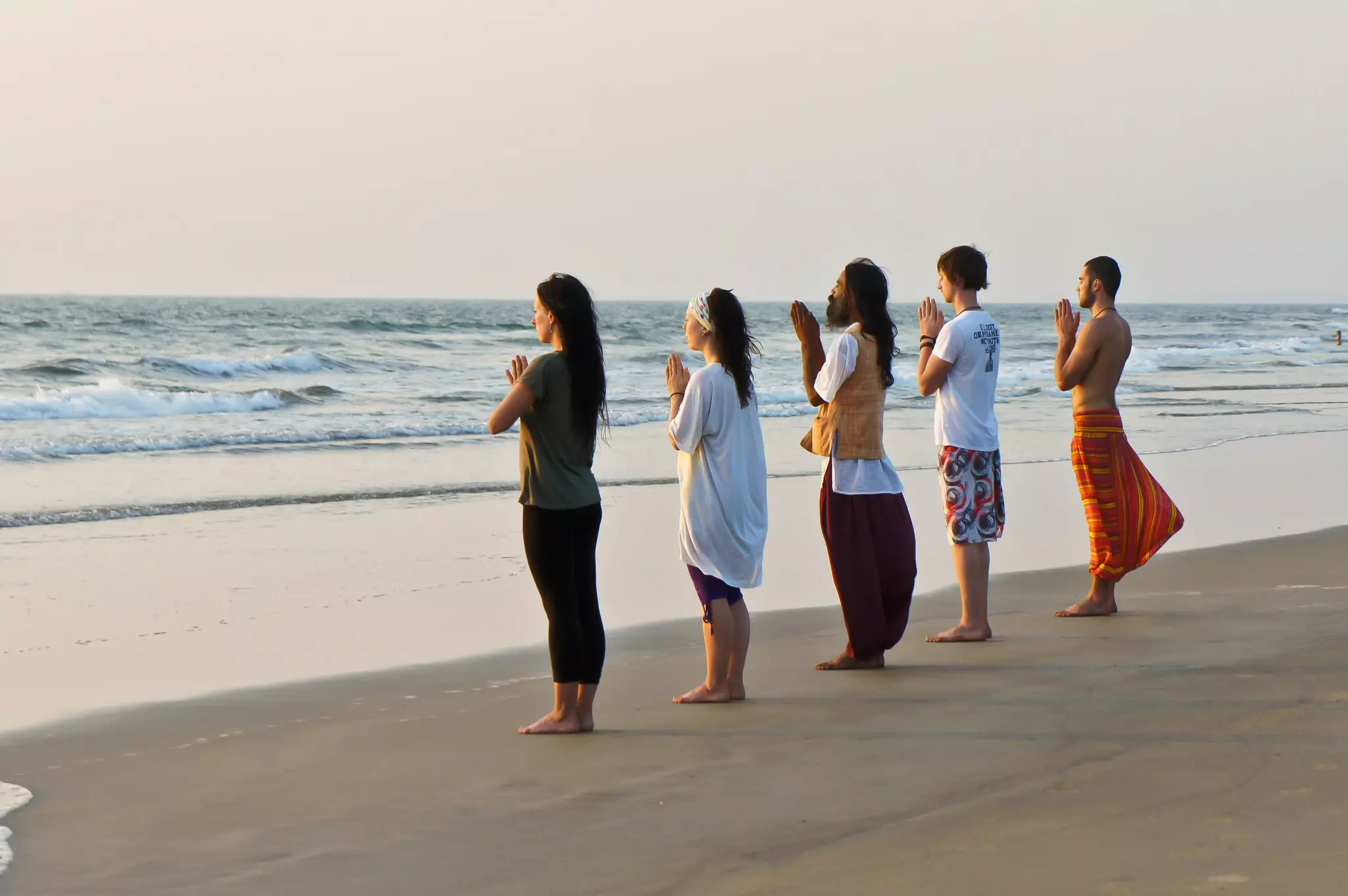 People practice yoga on the beach