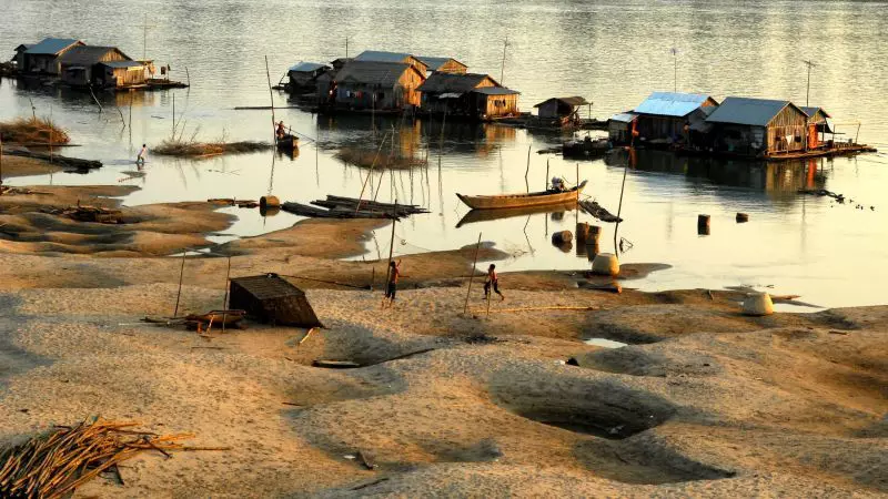 Boats and floating houses at Koh Trong Cambodia, with children playing