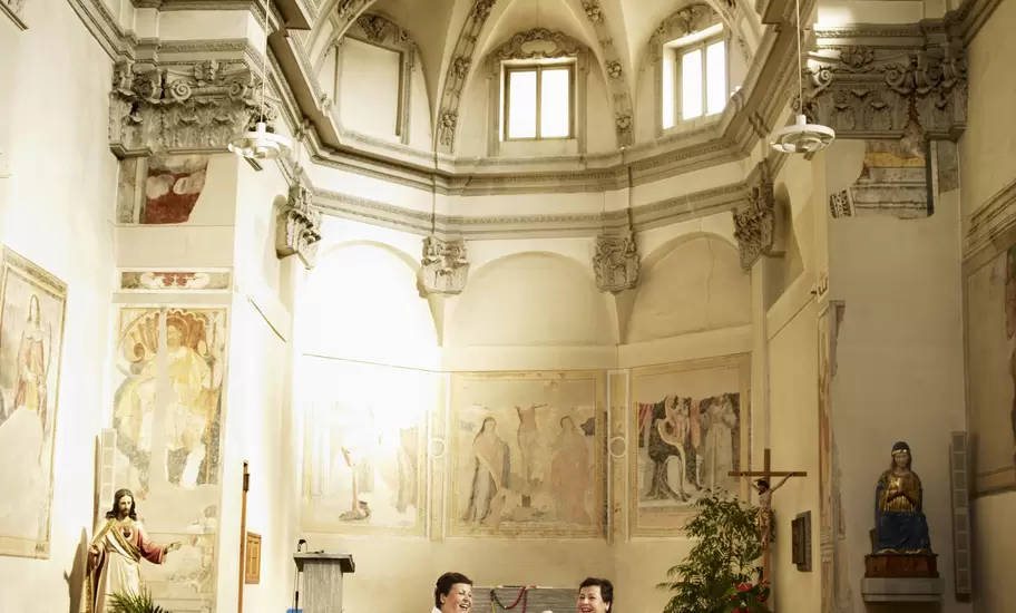 Two women singing and playing guitar in Bedigliora’s church.