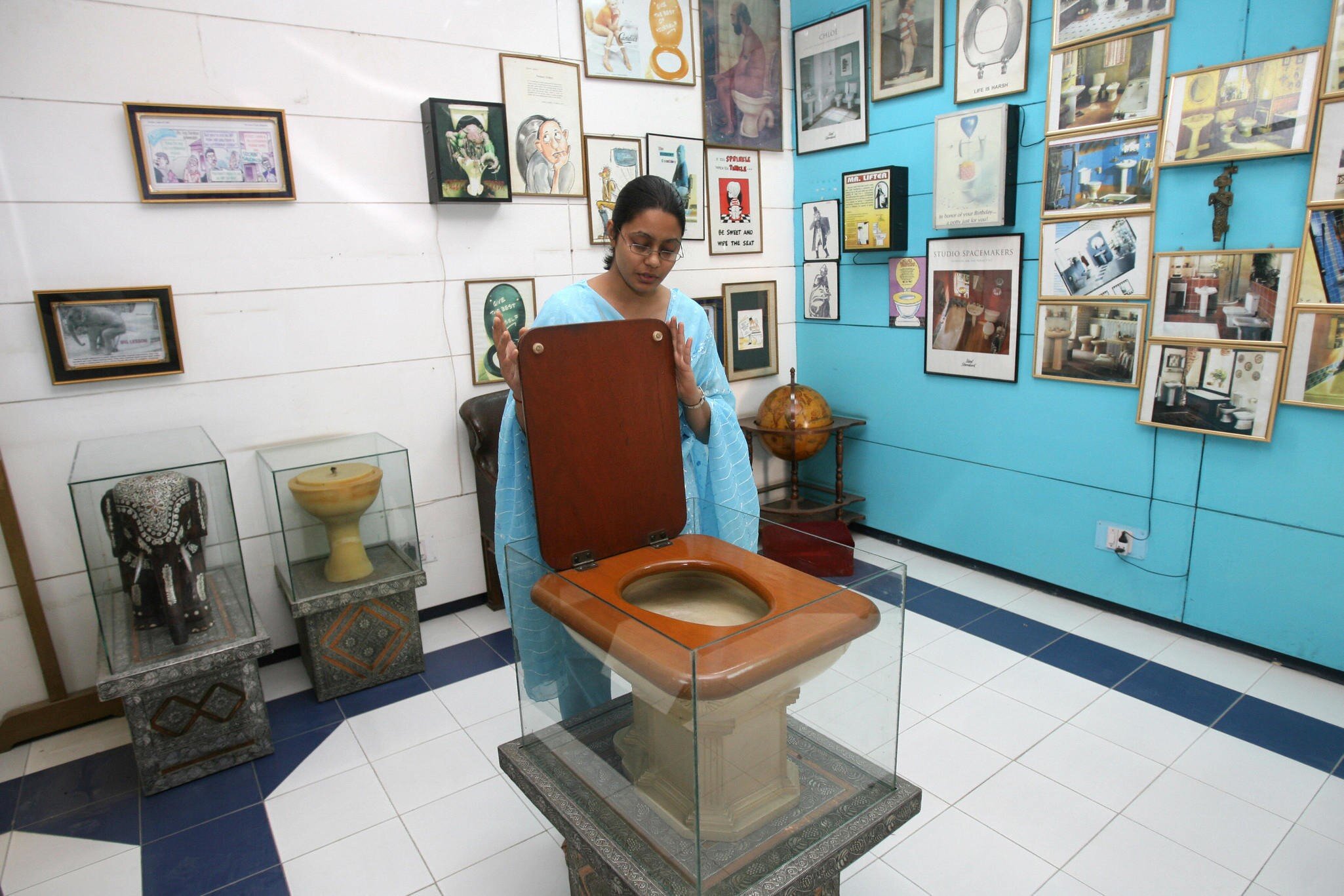 TO GO WITH STORY BY TRIPTI LAHIRI  An employee of the Sulabh International Museum of Toilets displays a Fancy Toilet used in the 1930s at the museum in New Delhi, 27 October 2007.   For India's low-cost toilet champion, each new loo means freedom ...