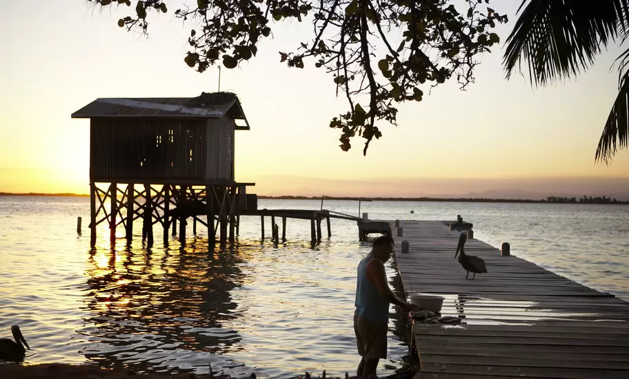 Fisherman cleaning fish on jetty at Tobacco Caye.
