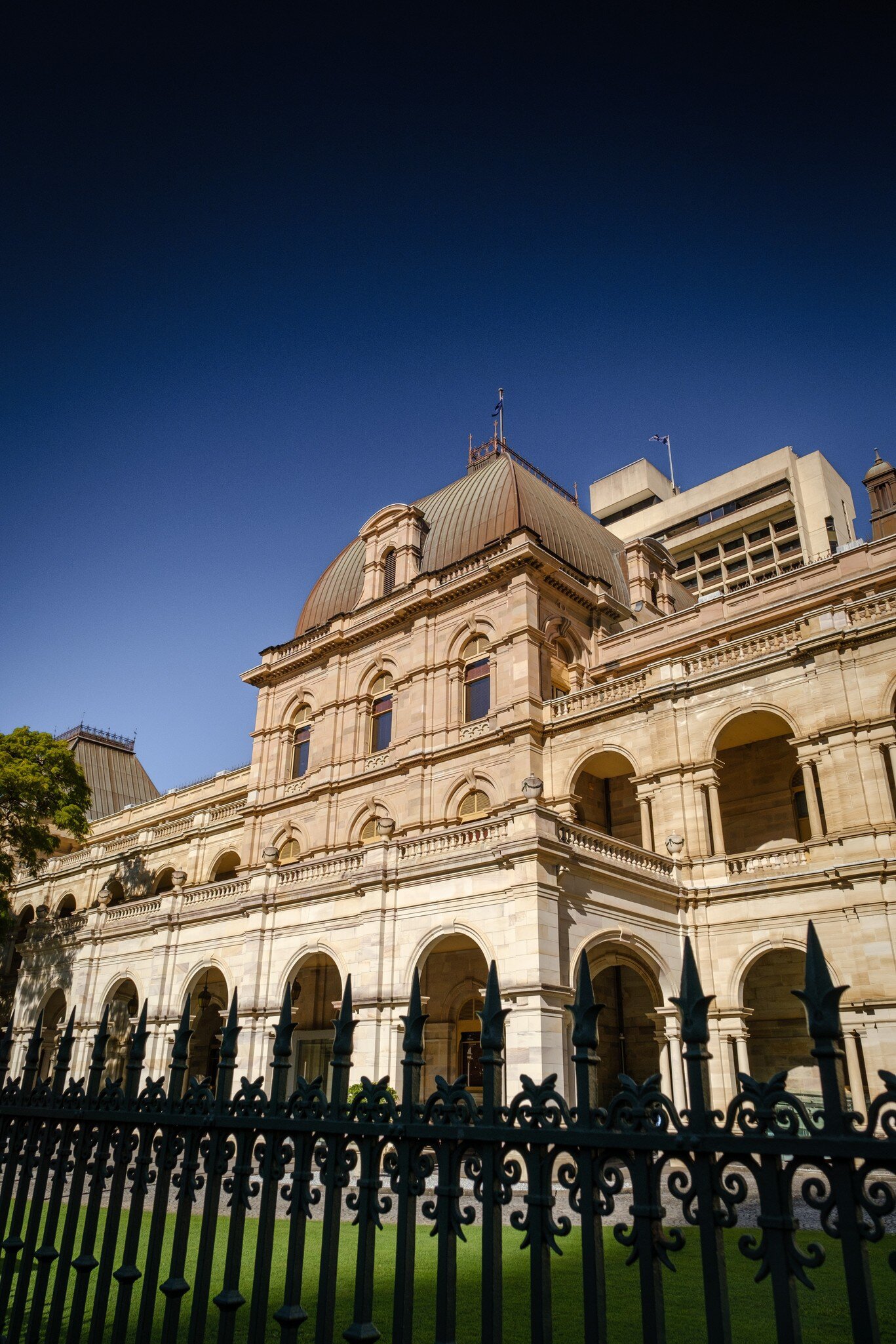 Exterior view of Queensland Parliament House with its sandstone facade and architectural columns. Brisbane, Australia.