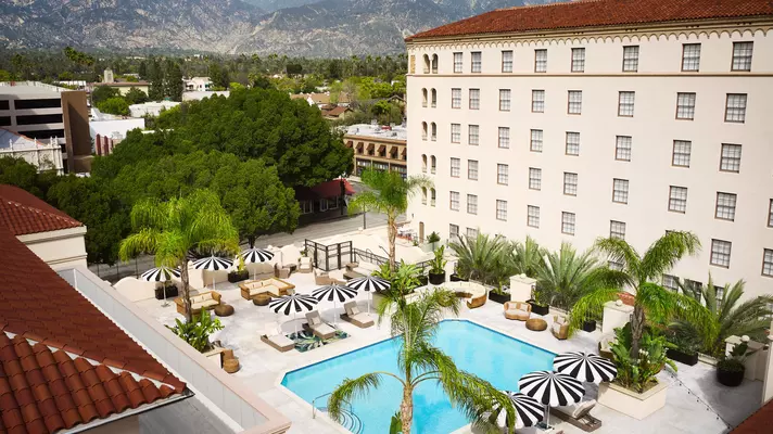 The swimming pool with stylish black and white umbrella-topped seating areas nearby.