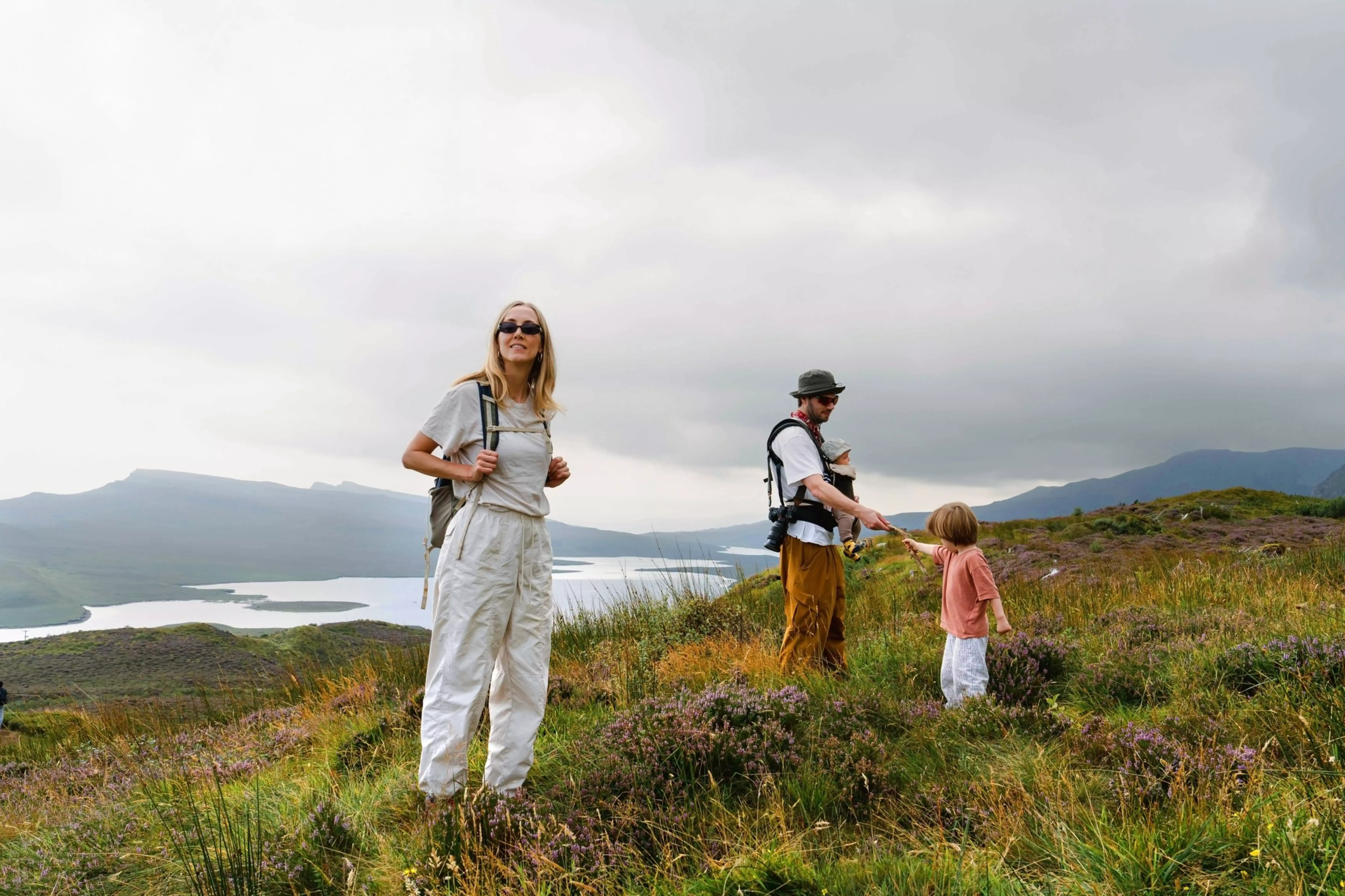 Charlie and Jessica Last hiking with their children with mountains and a loch in the background.
