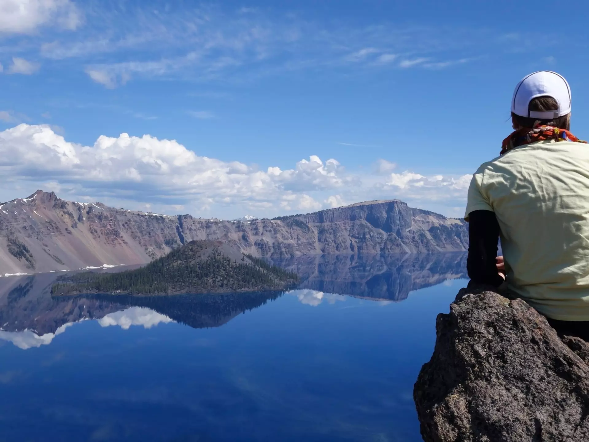 A lone young woman sitting on the rock in front of water in the Crater Lake National Park, Garfield Peak trail (OR, USA), License Type: media, Download Time: 2025-08-14T04:16:50.000Z, User: claramonitto, Editorial: false, purchase_order: 56530 - Guidebooks, job: Global Publishing-WIP, client: Washington, Oregon & Pacific Northwest 10, other: Clara Monitto