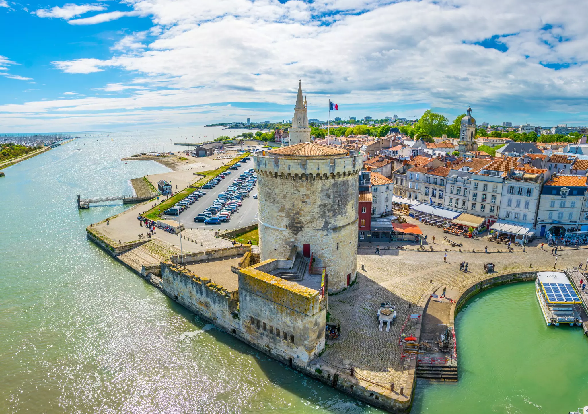 Seaside of a city with a tower in the foreground with several connected buildings behind it