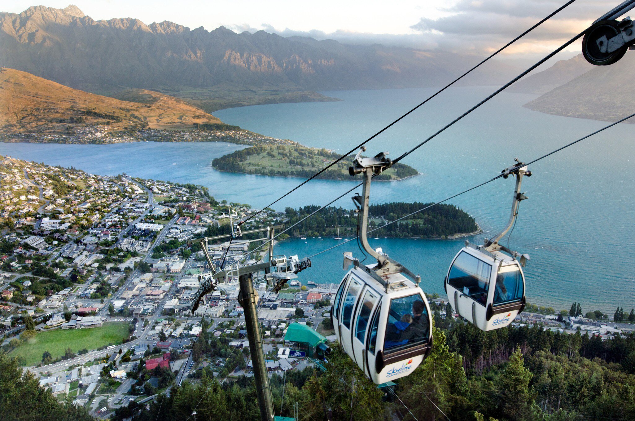 Two Queenstown Skyline Gondolas side-by-side during sunset.