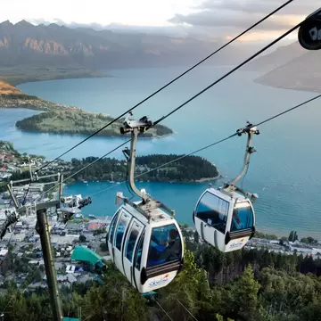 Two Queenstown Skyline Gondolas side-by-side during sunset.
