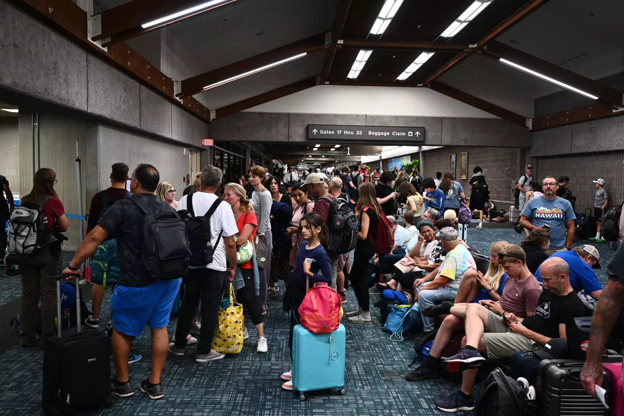 Passengers at Kahului Airport (OGG) in the aftermath of wildfires in western Maui. © Patrick T. Fallon / AFP via Getty Images