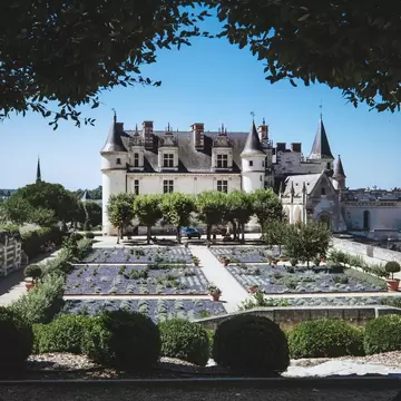 A view of the historic town of Amboise at the side of the River Loire, with the illuminated royal castle Chateau d'Amboise towering at hilltop. Amboise, Loire Valley, France.