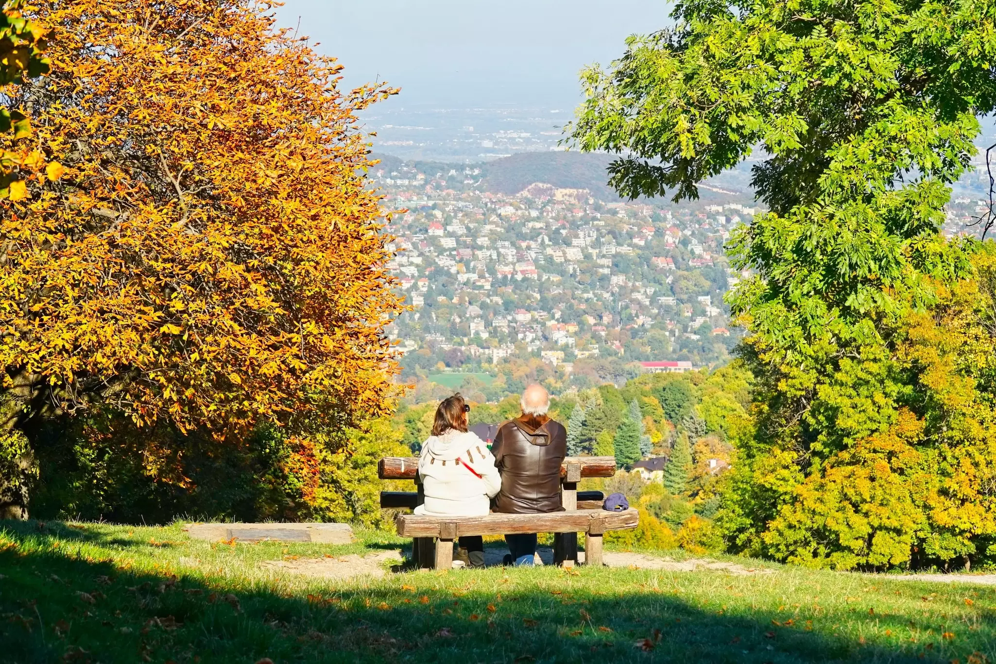 A couple enjoying the panoramic views from Normafa on a sunny day in Budapest, Hungary.