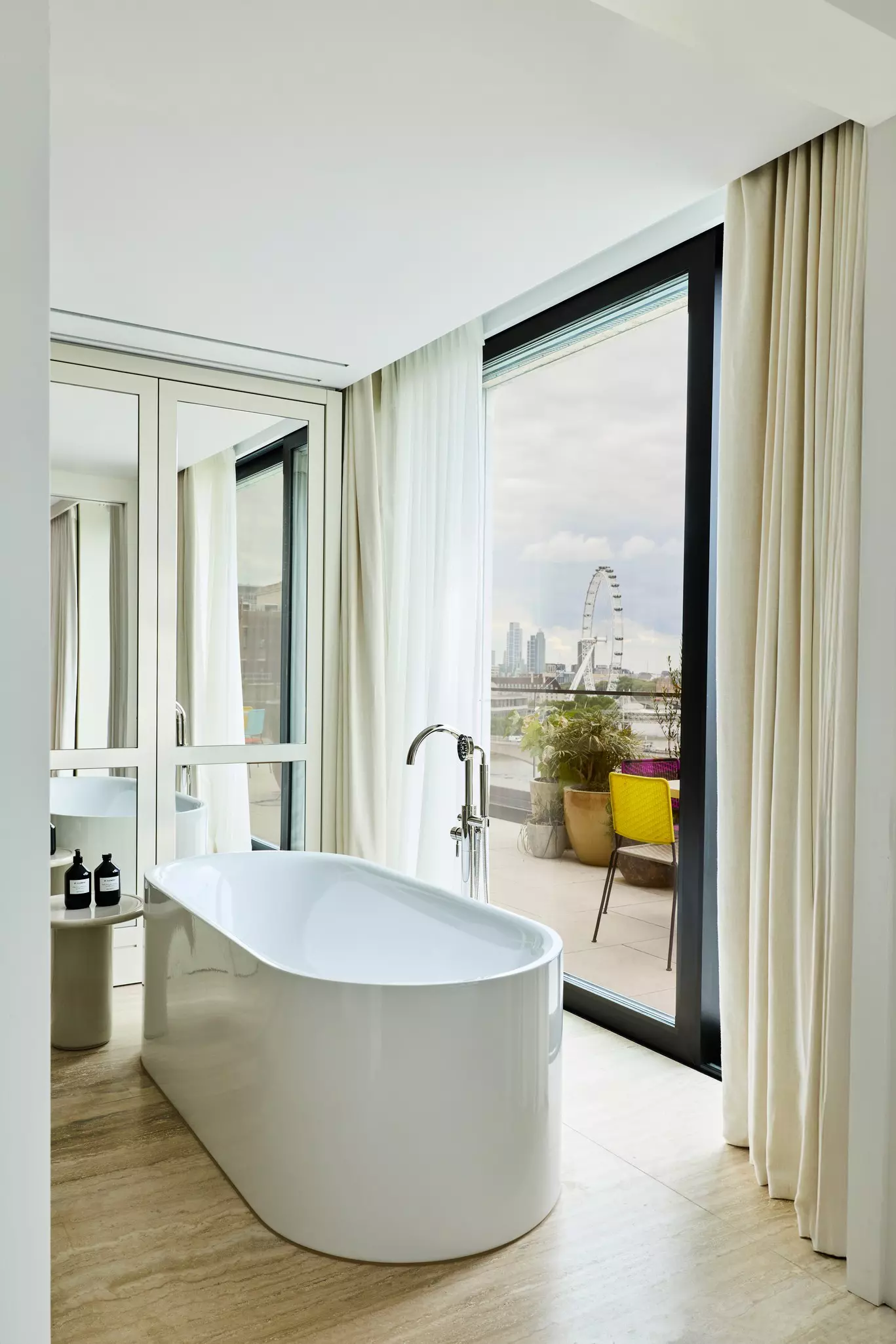 Bathtub in a room with a large window and view of a Ferris wheel